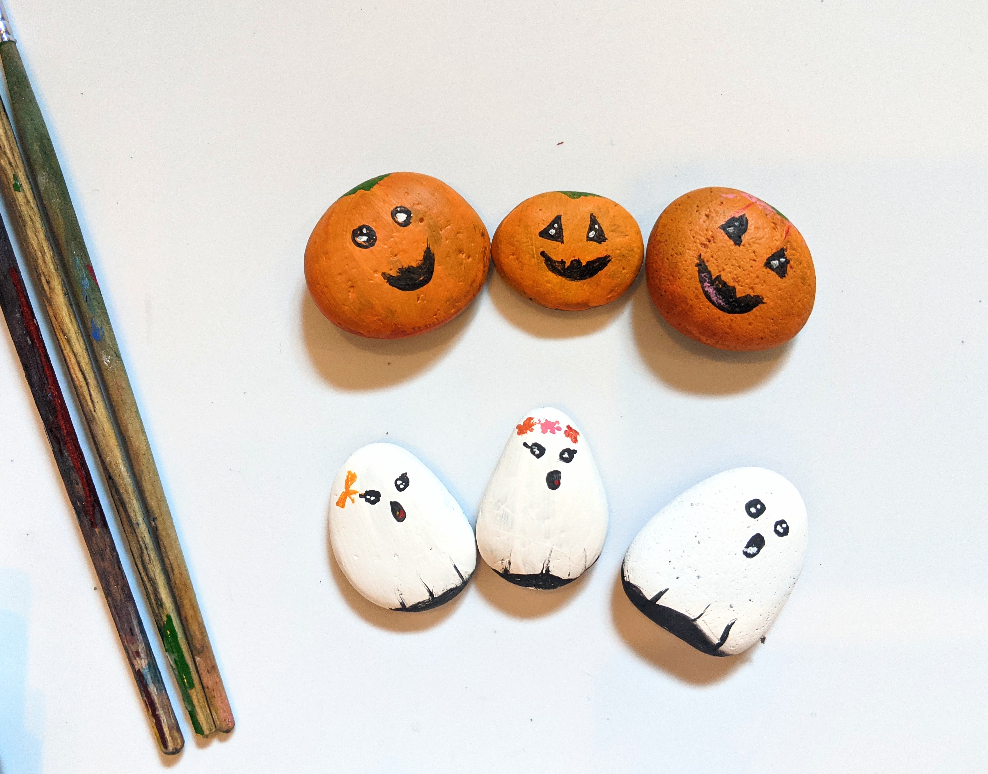 Easy halloween ghost and jack-o-lantern rock painting.